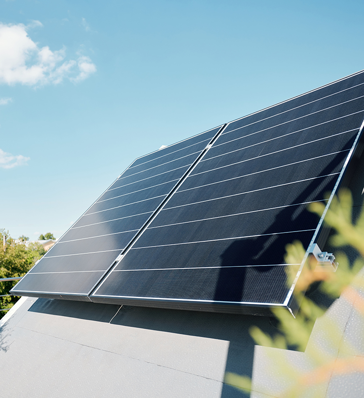 Solarmodule einer Photovoltaikanlage auf einem Dach bei klarem Himmel.
